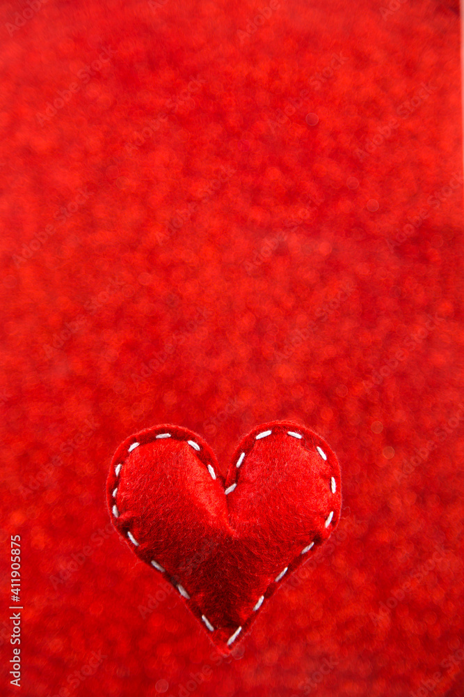 Handmade soft stitched felt heart on red shiny background, sequins in the side. The concept for Valentine's Day. Copy space. Handmade soft stitched felt heart on red shiny background, sequins in the side. The concept for Valentine's Day. Copy space.