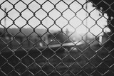 Close up of mesh fence with blurred buildings in the background