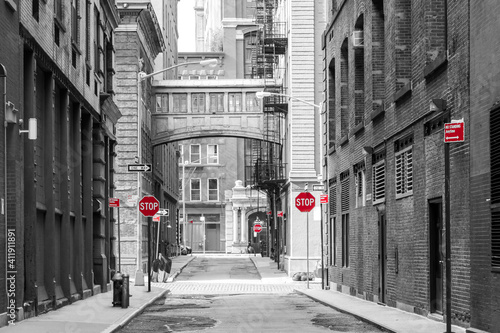 Red signs in a black and white cityscape at the intersection of Jay and Staple Streets in the Tribeca neighborhood of New York City