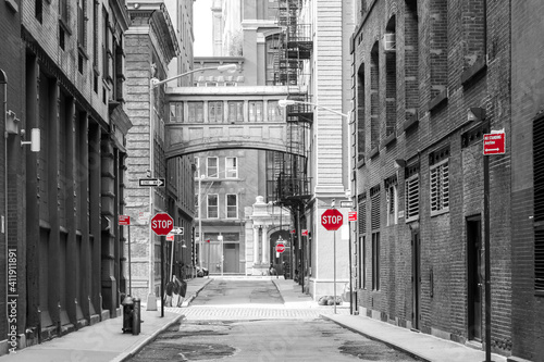 Red signs in a black and white cityscape at the intersection of Jay and Staple Streets in the Tribeca neighborhood of New York City