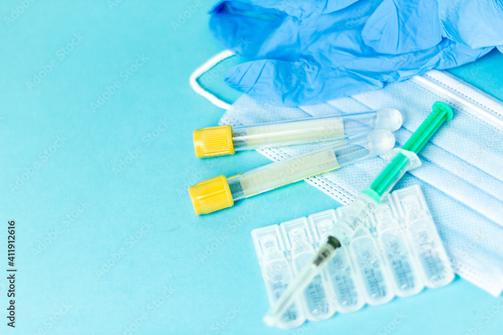 Medical vials for injection, syringe for injection, mask gloves on a blue background. Admission vaccination, flu shot.