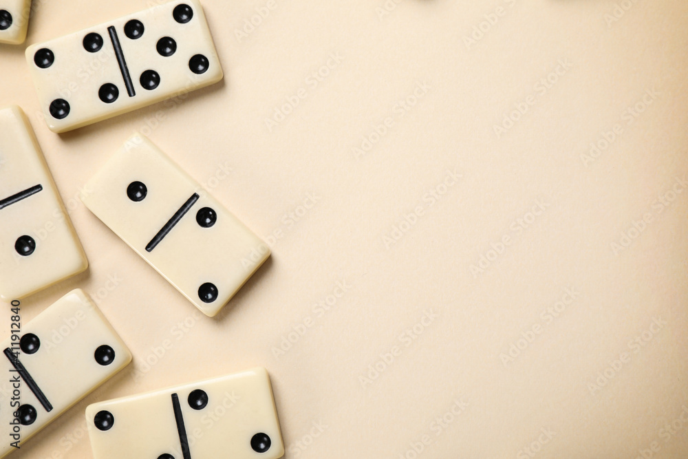 Classic domino tiles on beige background, flat lay. Space for text Classic domino tiles on beige background, flat lay. Space for text