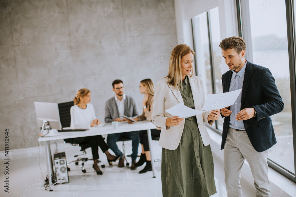 Foto de Man and woman discussing with paper in hands indoors in the ...