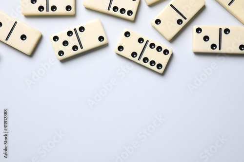 Classic domino tiles on white background  flat lay. Space for text