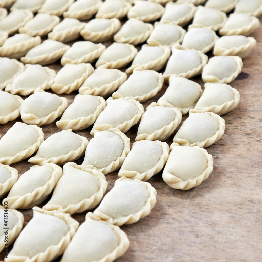 laying out dumplings on a wooden tray laying out dumplings on a wooden tray