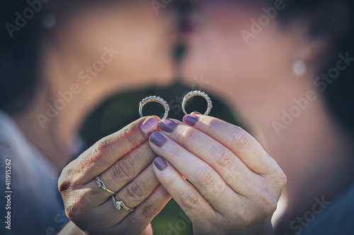Same sex couple holding wedding rings