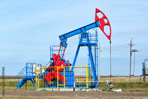 A bright oil rig on a sunny day against a blue sky. Front view. Horizontal.