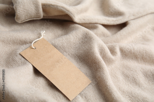 Warm beige cashmere sweater with tag, closeup