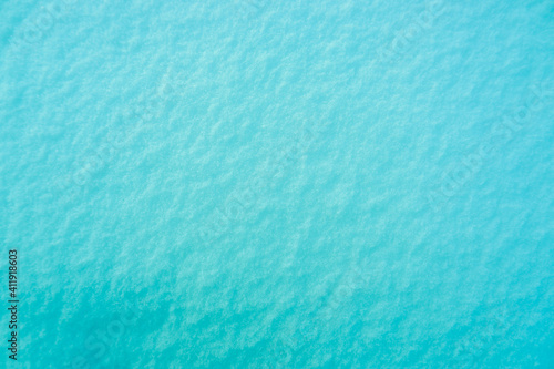 Colored snow as a background. Turquoise background.