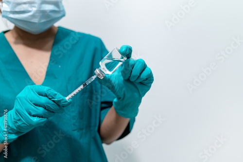 Asian doctor with Syringe and vaccine for protect covid-19 virus on white background