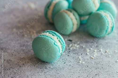 Macaroons. Delicious French desserts. Macaroons with coconut flakes. Blue macaroons on the table