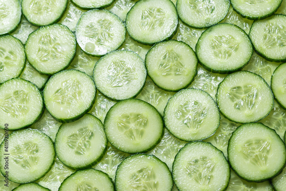 Fresh green slices of cucumber as background. Fresh green slices of cucumber as background.