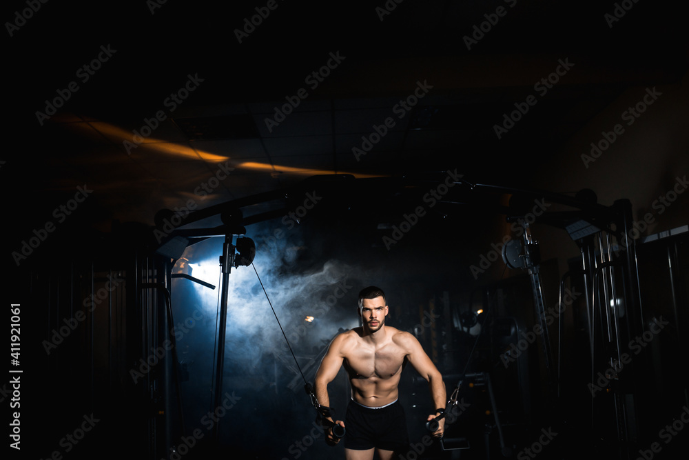 Muscular Fitness Bodybuilder Doing Heavy Weight Exercise In The Gym. Athlete doing pectoral muscle exercise Muscular Fitness Bodybuilder Doing Heavy Weight Exercise In The Gym. Athlete doing pectoral muscle exercise