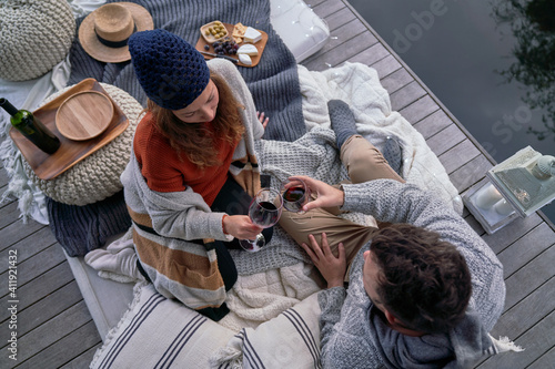 Couple enjoying wine and cheese on patio cushions photo