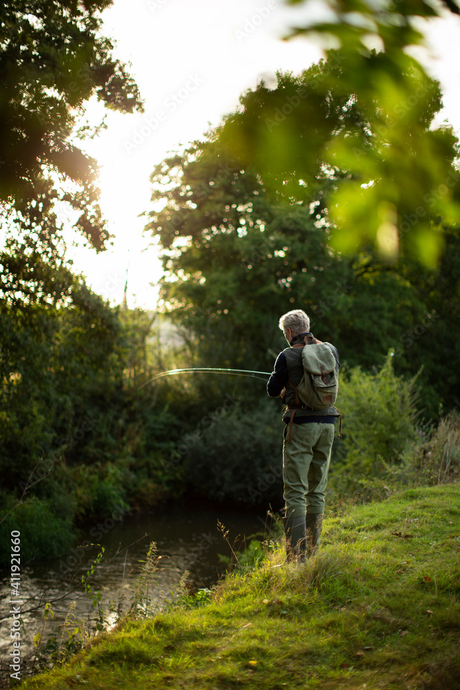 Man fly fishing at riverbank