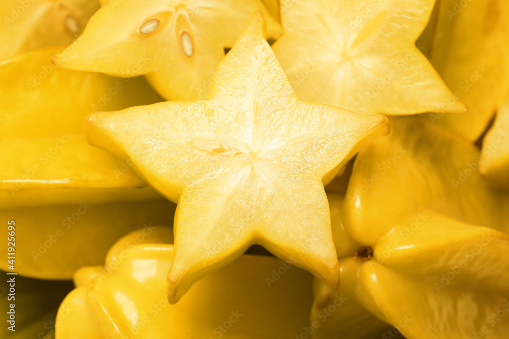 Fototapeta premium Cut and whole carambolas as background, closeup