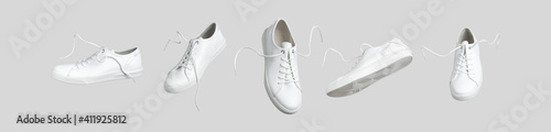 Flying white leather womens sneakers isolated on gray background, different kind. Fashionable stylish sports casual shoes. Creative minimalistic layout with footwear. Advertising for shoe store, blog