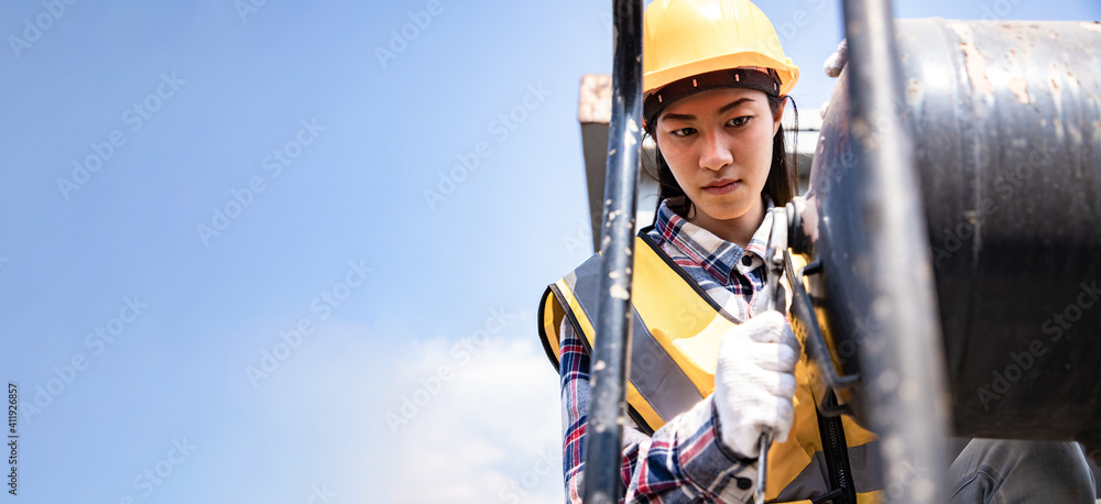 Engineers woman working on train garage site and using wrench for repair boiler of train with blue sky. Service and Technician concept. - obrazy, fototapety, plakaty 