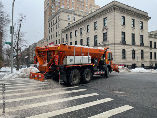 Manhattan, New York, USA. February 2021.  A Sanitation Department  truck spreading salt and san on a street in the Upper West Side area of Manhattan as snow is forcast. photo