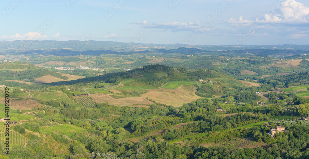 Typical landscape with rolling hills and vineyards around San Gimignano town, Tuscany, Italy