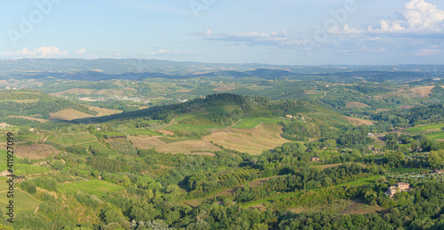 Typical landscape with rolling hills and vineyards around San Gimignano town, Tuscany, Italy