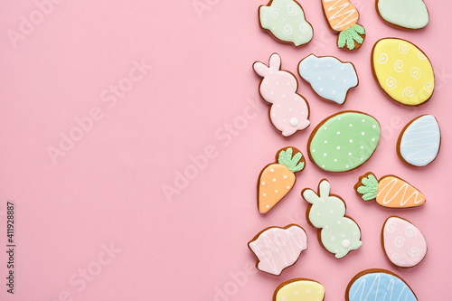 Easter greeting card with colorful rabbits, eggs, chickens and carrots gingerbread cookies on pink background with copy space. Mock up. Banner. Top view.