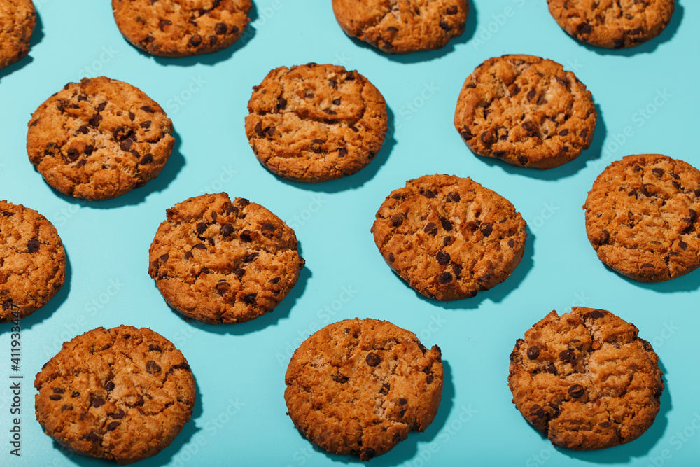 Oatmeal cookies with chocolate chip pattern and patterns on a light blue background. Full screen, top view Oatmeal cookies with chocolate chip pattern and patterns on a light blue background. Full screen, top view