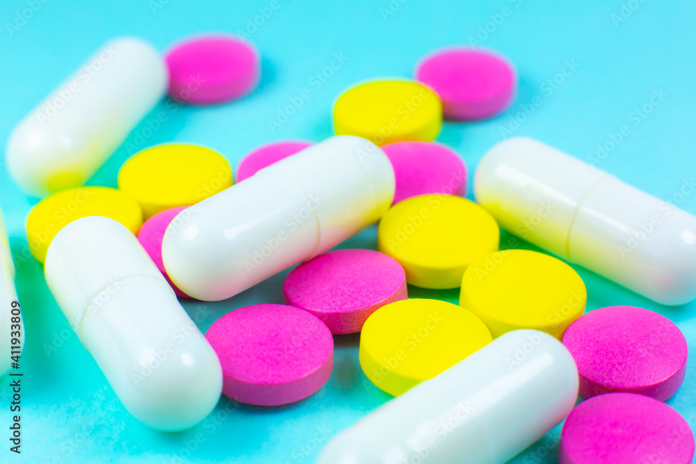 Colored pills and tablets on green background. Close up. Medical treatment concept. Colored pills and tablets on green background. Close up. Medical treatment concept.