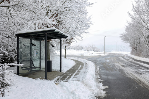 Bus stop by the snowy road in winter © leomalsam