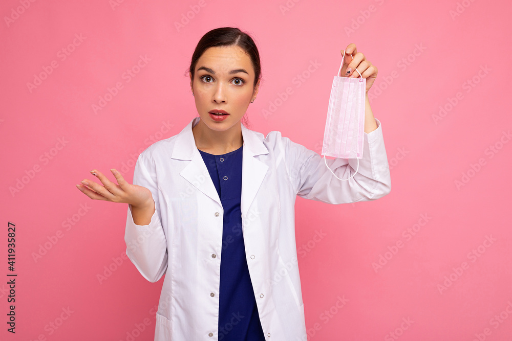 Surprised caucasian woman showing protection face mask isolated on pink background. Coronavirus or Covid-19 Concept Surprised caucasian woman showing protection face mask isolated on pink background. Coronavirus or Covid-19 Concept