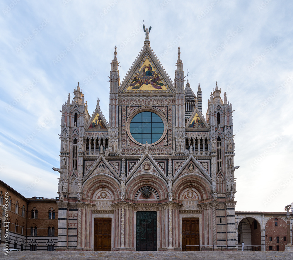 Duomo di Siena at sunrise, a black and white marble church typical of medieval gothic architecture, in the famous town of Siena, Tuscany, Italy