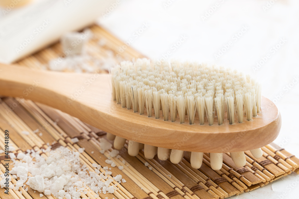 Sea salt , wooden mat, massage wooden brush on white background Sea salt , wooden mat, massage wooden brush on white background