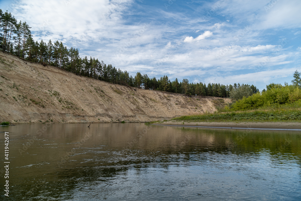 Right high bank with the dreams of the Khoper river. The sun will soon disappear over the horizon. Rafting in the summer on a kayak on the river. Individual hike. Solo.