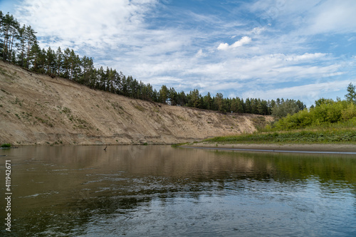 Right high bank with the dreams of the Khoper river. The sun will soon disappear over the horizon. Rafting in the summer on a kayak on the river. Individual hike. Solo.