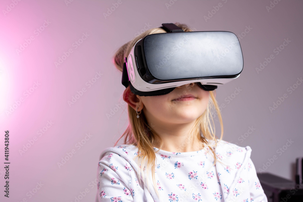 Girl using virtual reality headset at home with pink neon light. Girl using virtual reality headset at home with pink neon light.