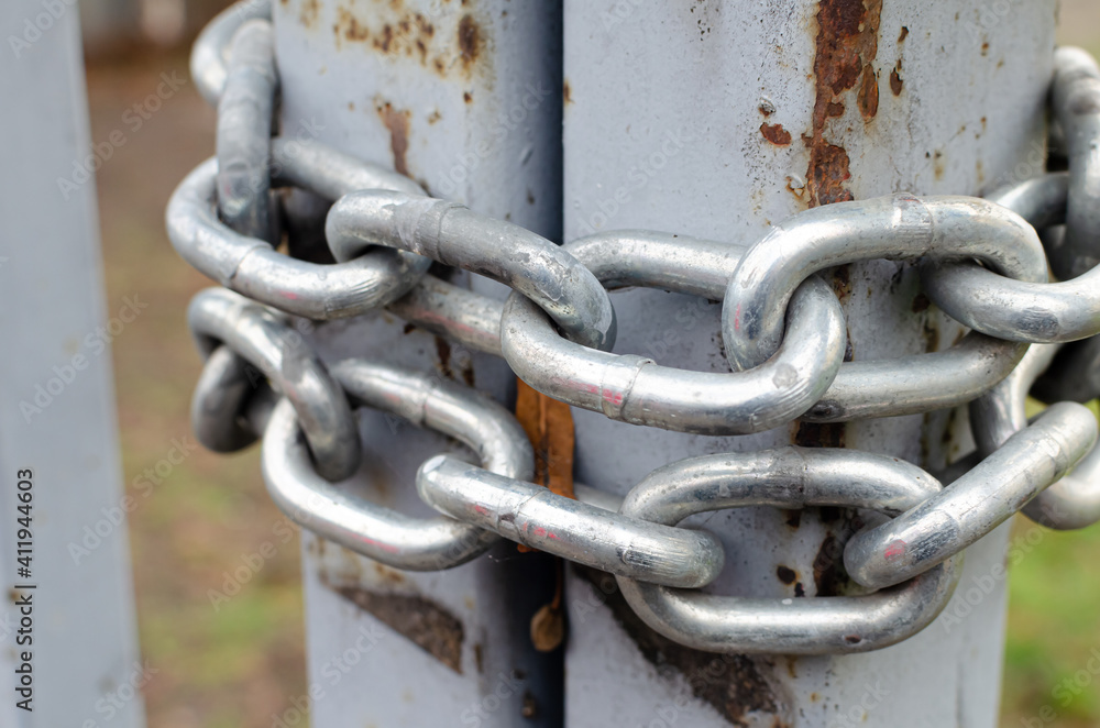 Rusted gates are locked with a chain. Close up Rusted gates are locked with a chain. Close up