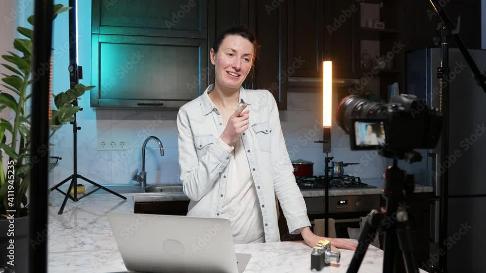 Woman blogger or vlogger streaming online on social media to her subscribers. Woman using microphone, video camera and other blogging set ups at her house while talking on camera. Woman blogger or vlogger streaming online on social media to her subscribers. Woman using microphone, video camera and other blogging set ups at her house while talking on camera.