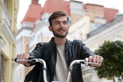 Handsome young bike messenger sits on bicycle and looks ahead photo