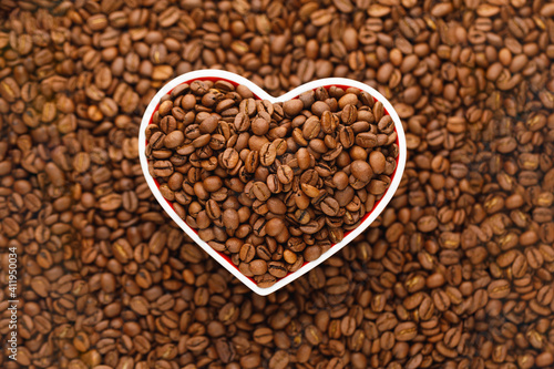 roasted coffee beans in heart shaped plate background © nikkytok