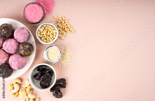 Ingredients Homemade pink matcha dragon fruit energy balls, top view, healthy sweets made of nuts and date, prunes, cashew nuts, Pine nuts. Vegeterian diet candy brain sustainable food. Copy space