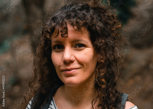 Portrait of a curly-haired woman in the middle of the forest