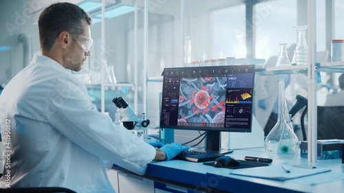 Advanced Medical Science Laboratory: Medical Scientist Working on Personal Computer with Screen Showing Virus Analysis Software User Interface. Scientists Developing Vaccine, Drugs and Antibiotics.