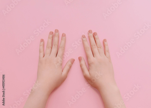 Manicure Photo for posters and banners in minimal style Female hands with matt nude nail polish on light pink background