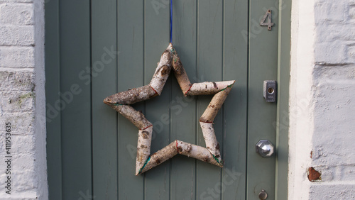 Star shape made out of silver birch tree branches hanging on door