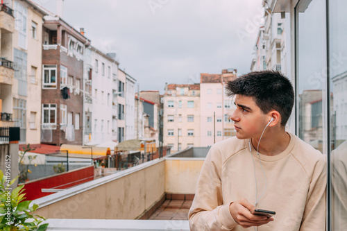 young man with phone and headphones in the city