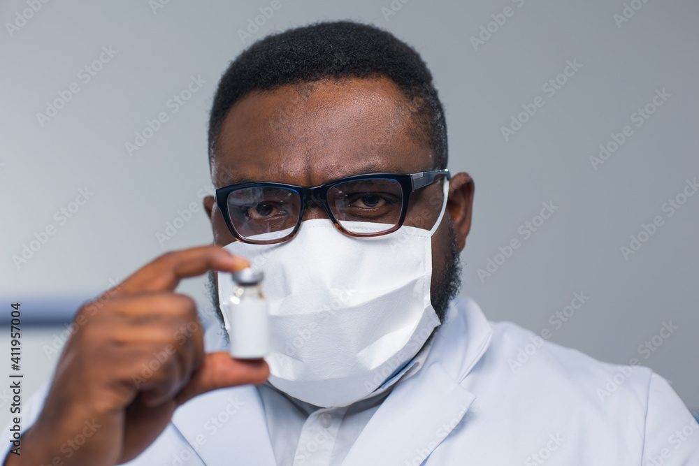 Professional African-American scientist is working on a vaccine in a modern scientific research laboratory. Doctor is looking on a vaccine tube. Future technology and science. Professional African-American scientist is working on a vaccine in a modern scientific research laboratory. Doctor is looking on a vaccine tube. Future technology and science.