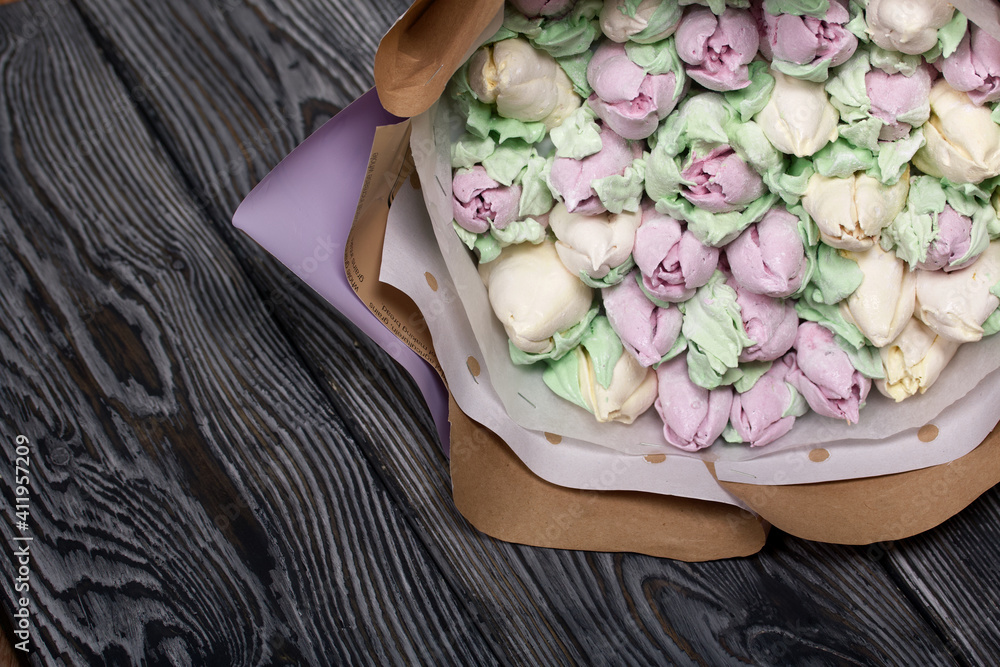 Zephyr bouquet. Marshmallow tulips are collected in a bouquet and wrapped in craft paper. Lies on pine boards. Zephyr bouquet. Marshmallow tulips are collected in a bouquet and wrapped in craft paper. Lies on pine boards.