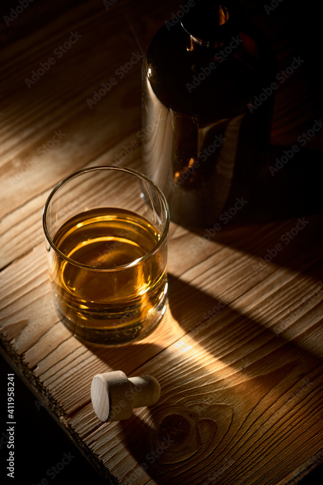 A glass of whiskey on a wooden table