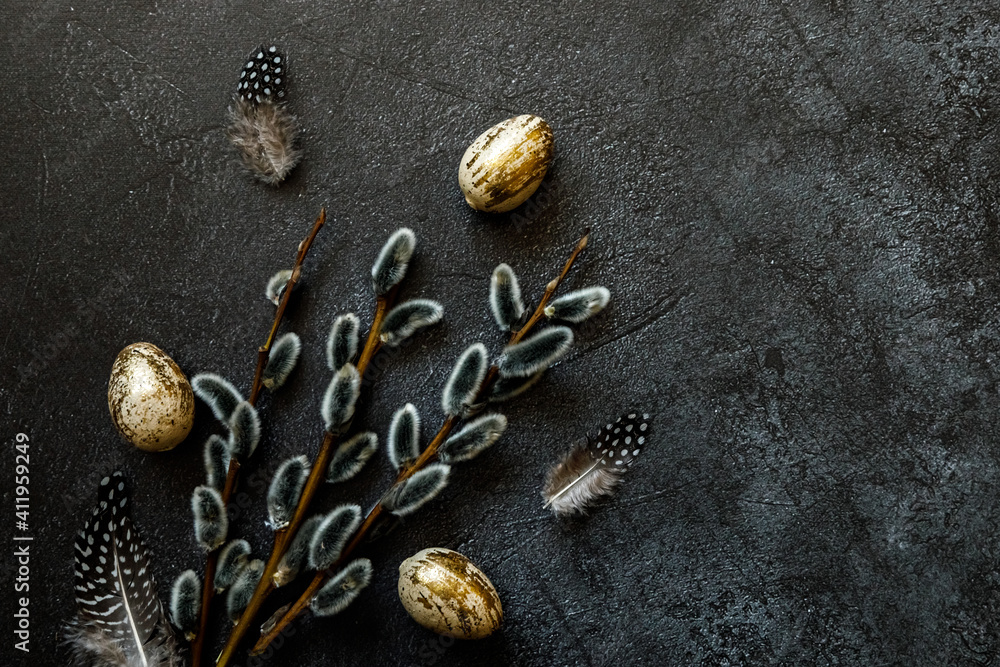 Happy Easter concept. Preparation for holiday. Golden decorated easter eggs willow feather on trendy grunge scratched dark black shale background. Simple minimalism flat lay top view, copy space - obrazy, fototapety, plakaty 
