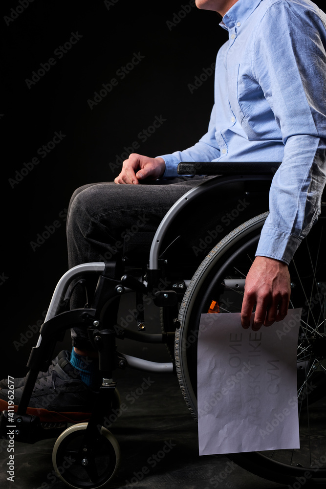 desperate disabled male sits with job search paper down, unhappy and hopeless. no social life and support. cropped man sitting on wheelchair desperate disabled male sits with job search paper down, unhappy and hopeless. no social life and support. cropped man sitting on wheelchair